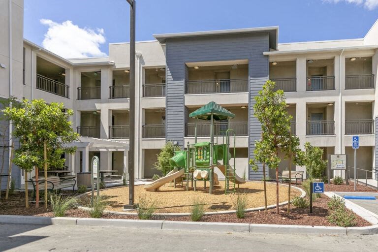 an apartment building with a playground in front of it