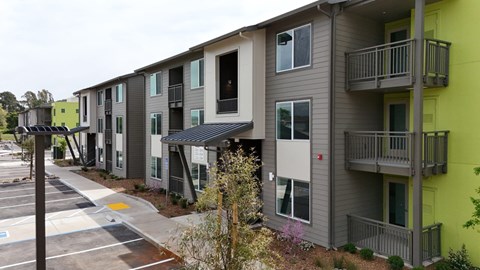 Apartment building with a parking lot in front.