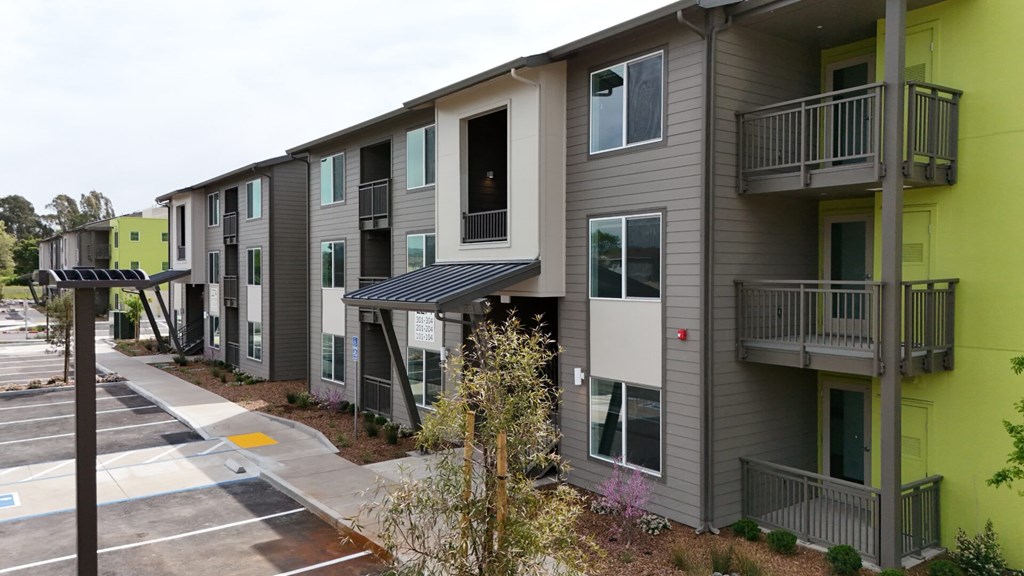 Apartment building with a parking lot in front.