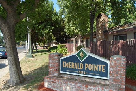 a sign for emerald point in front of a house