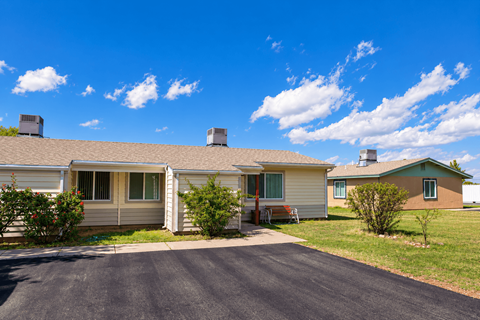 A sunny day in a residential area with houses and a clear blue sky.