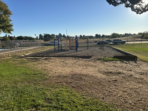 A construction site with a fence and a few trees in the background.