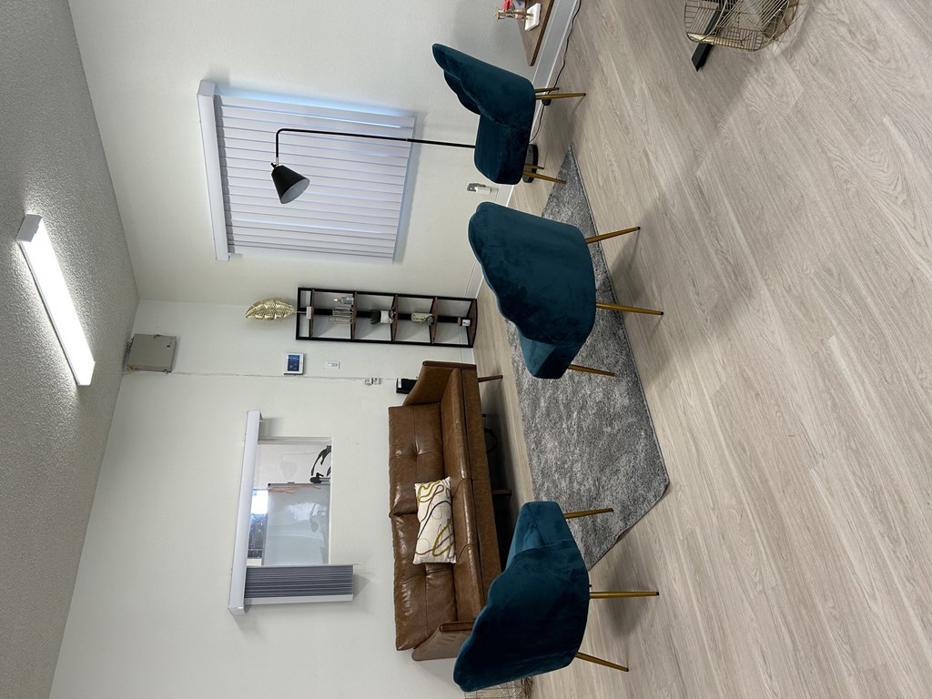 an aerial view of a living room with blue chairs and a mirror