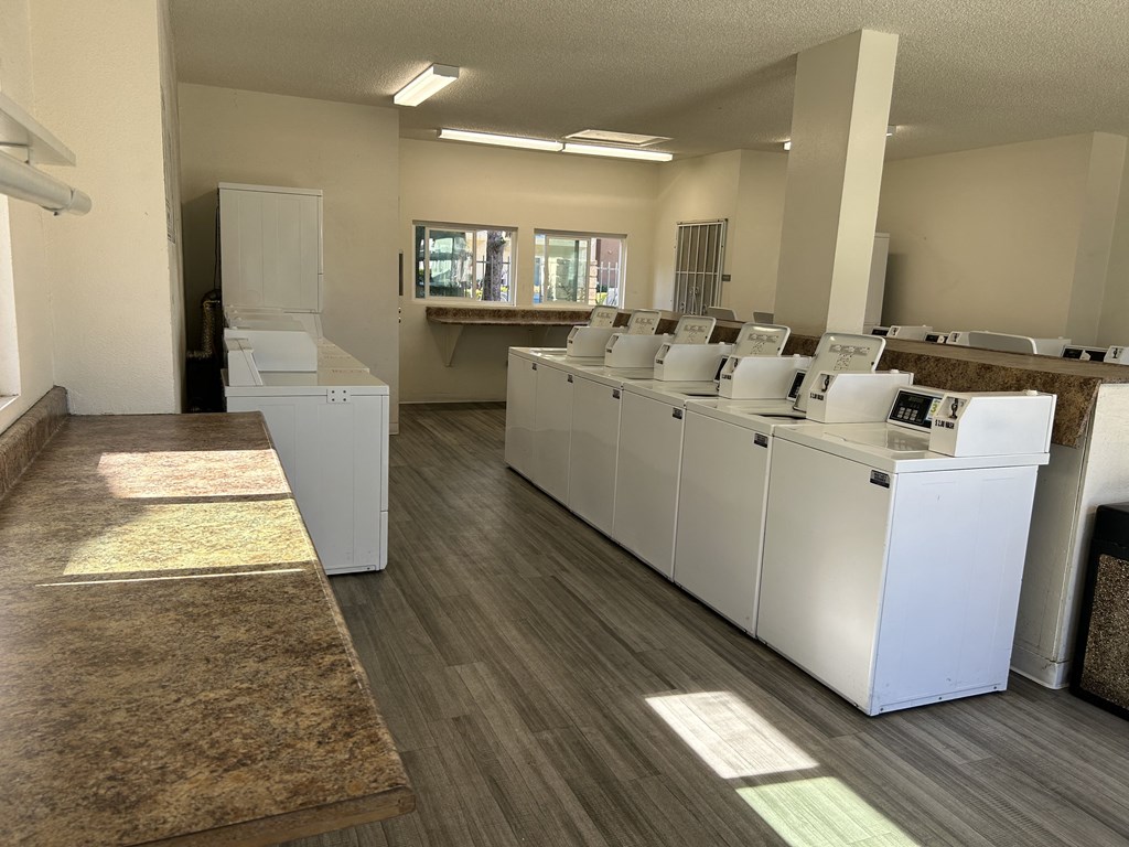 a row of washers and dryers in an empty room
