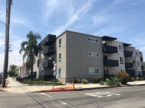 A modern apartment building with a bicycle lane in front.