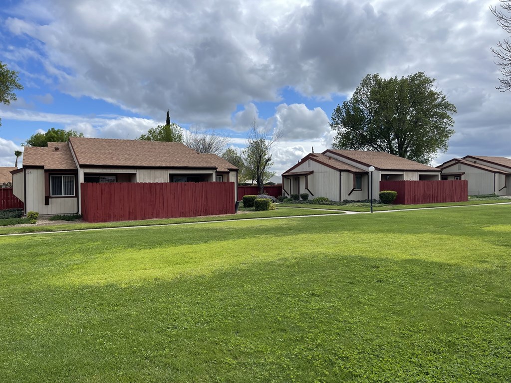 a house with a yard and a red fence