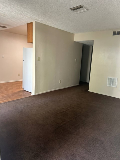 an empty living room with wood flooring and white walls