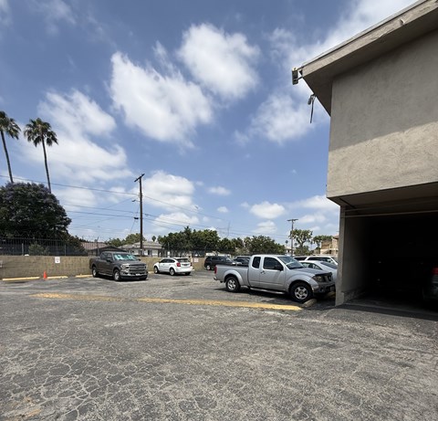 A parking lot with cars and a building on the right.