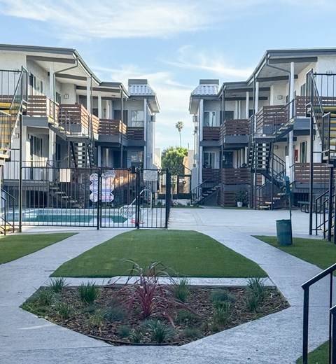 A view of apartment buildings with a small garden in the foreground.