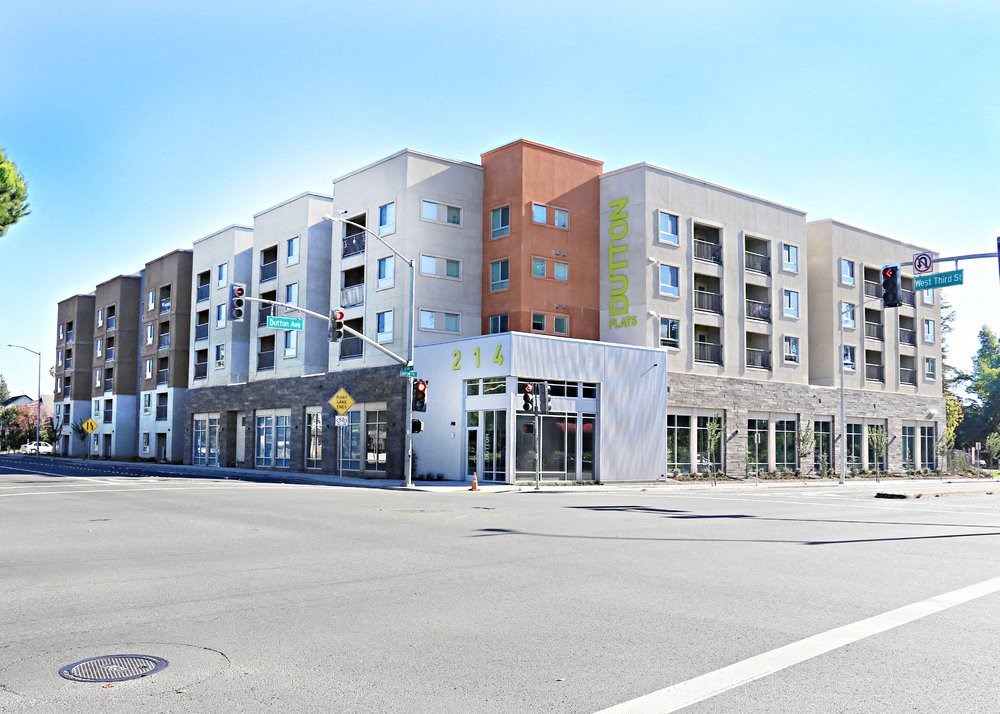 A street view of a multi-story building with the name "Dutton Flats" on the side.