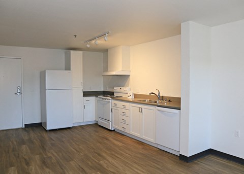 A kitchen with white appliances and cabinets.