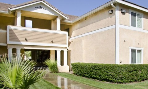 A house with a well-manicured lawn and a potted plant.