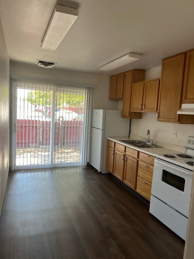 an empty kitchen with a sliding glass door to a patio