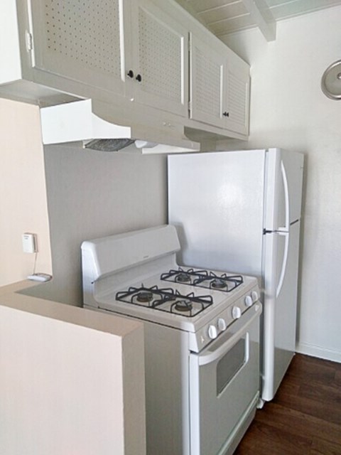 A white stove and refrigerator in a kitchen.