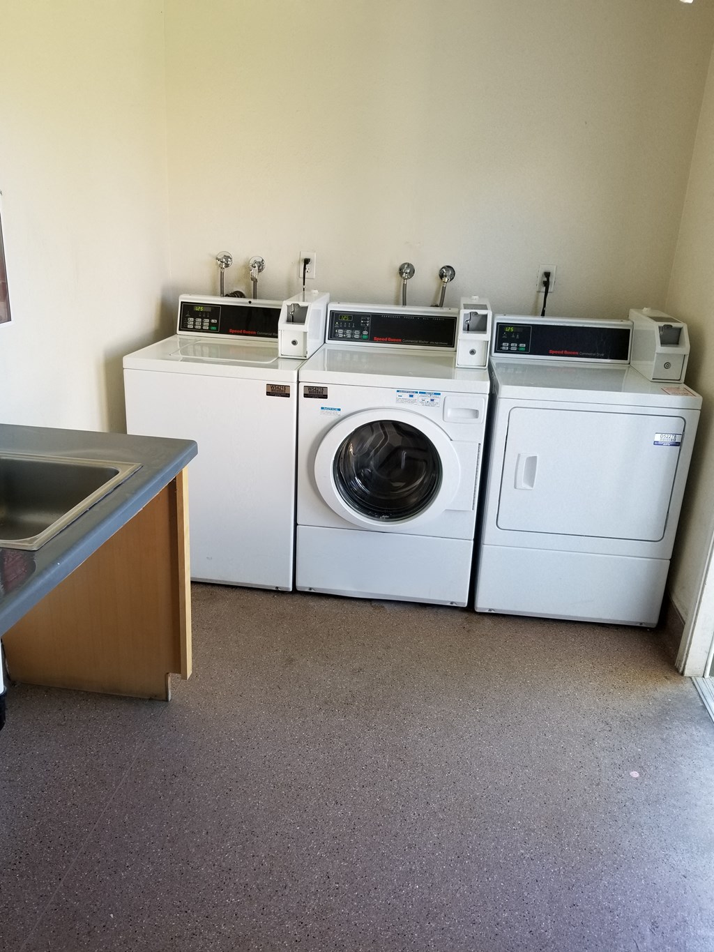 a laundry room with washing machines and a sink