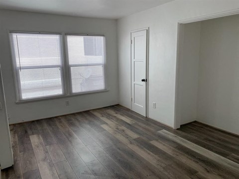 the living room of an empty house with wood floors