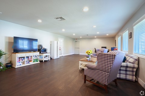 A living room with a checkered chair and a television.