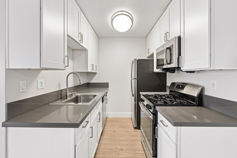A kitchen with white cabinets and a black stove top oven.