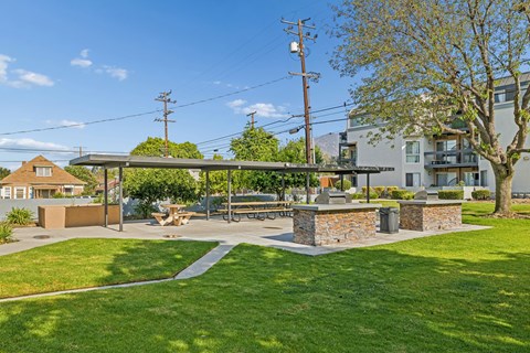 A sunny day at a park with a picnic table and a stone wall.