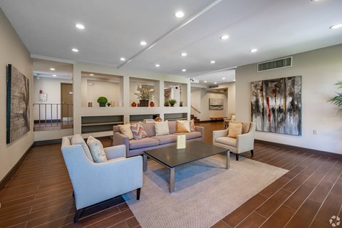 A spacious living room with a glass table and comfortable seating.