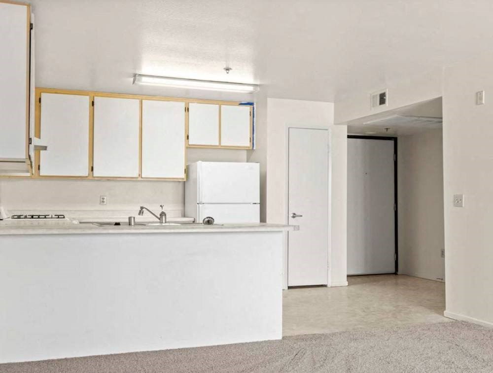 a kitchen with a white counter top and a white refrigerator
