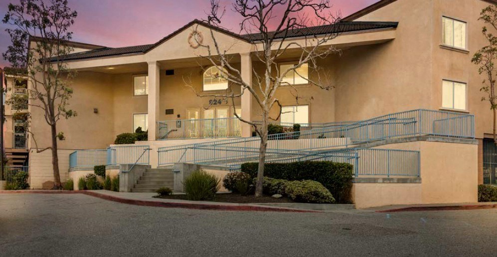 a large tan building with a tree in front of it