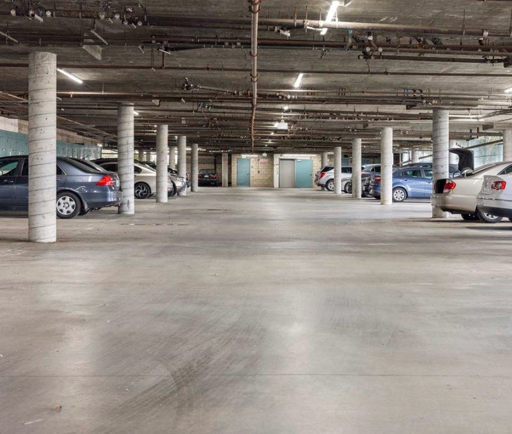a parking garage with cars parked on the side of the road