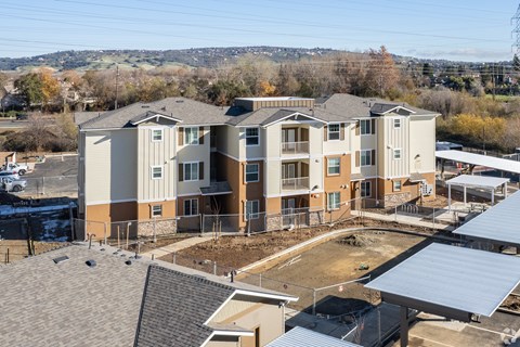 A large, multi-story residential building with a parking lot in front.