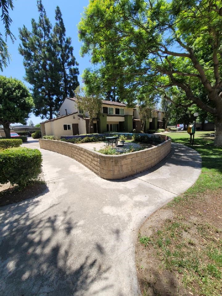 a walkway with a fountain in front of a house