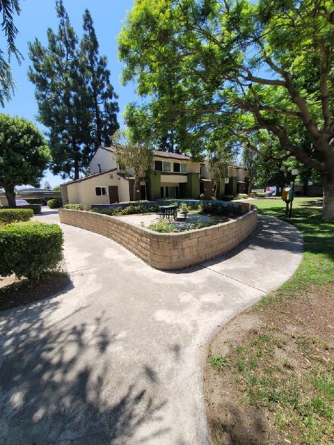 a walkway with a fountain in front of a house