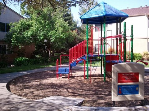 a playground with a blue and red swing set