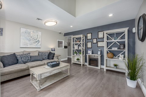 A living room with a grey couch and a wooden coffee table.