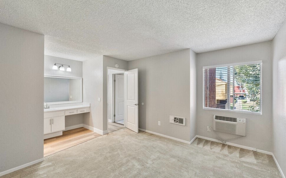 an empty living room with a large window and a bathroom at Brookhollow Apartments, West Covina , CA 91792