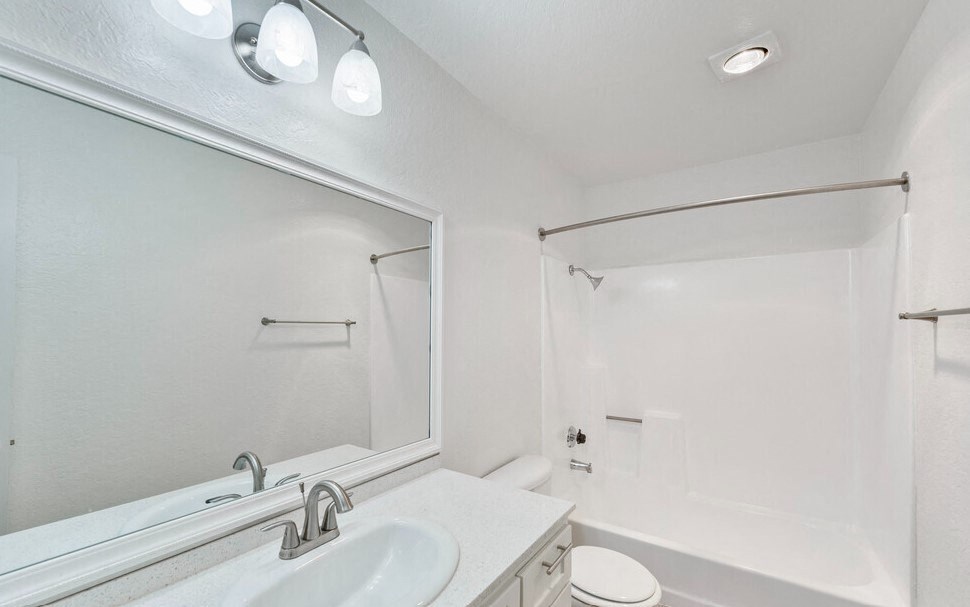 a bathroom with a mirror and a sink and a shower at Brookhollow Apartments, California
