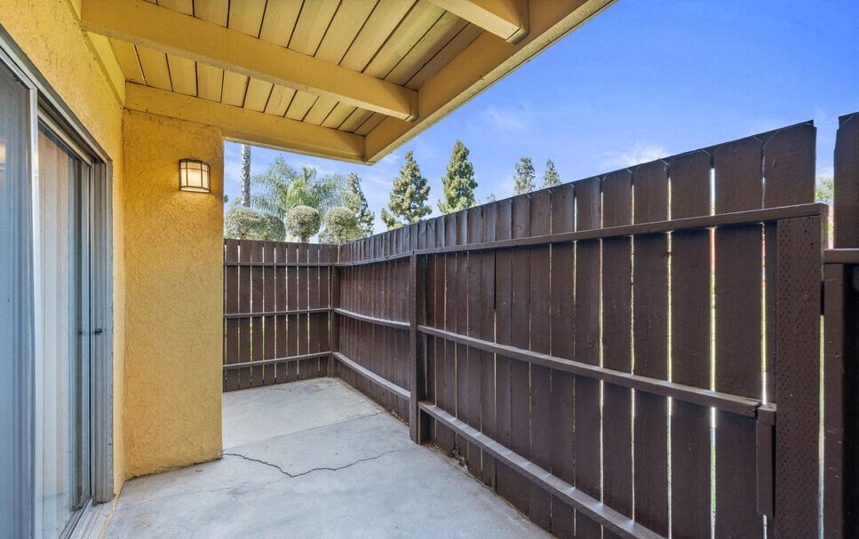 the patio has a wood fence and a glass door at Brookhollow Apartments, West Covina , California