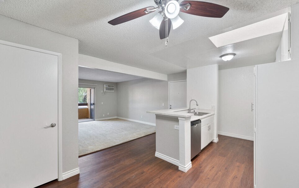 an empty kitchen and living room with a ceiling fan at Brookhollow Apartments, California