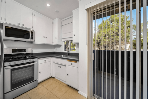 A kitchen with white cabinets and appliances.