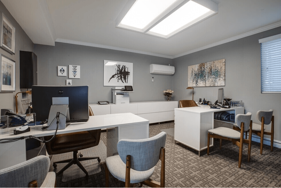 A modern office space with a skylight, desks, and chairs.