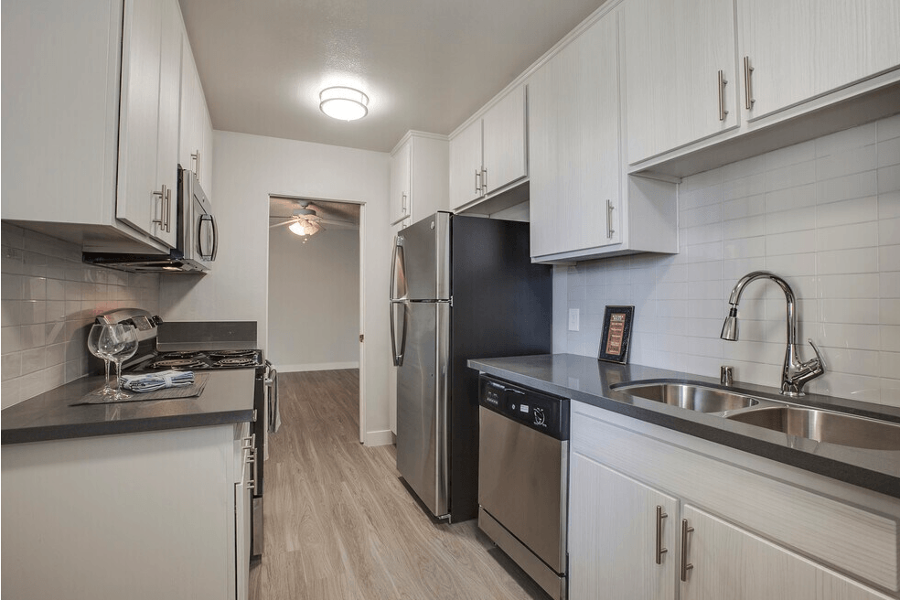 A kitchen with white cabinets and stainless steel appliances.