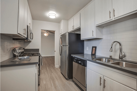 A kitchen with white cabinets and stainless steel appliances.