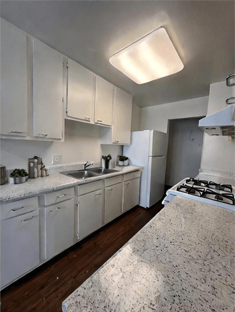 A kitchen with white cabinets and a granite countertop.