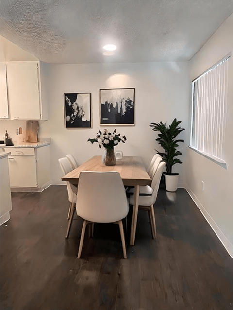 A dining room with a table and chairs.