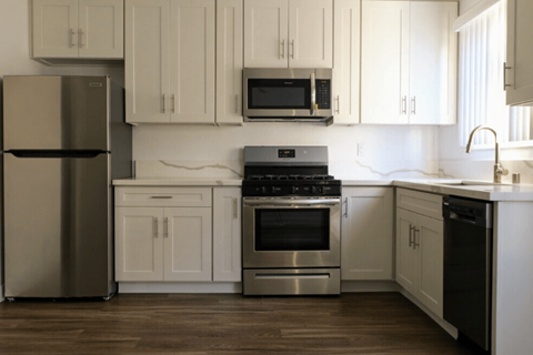 A modern kitchen with stainless steel appliances and white cabinets.