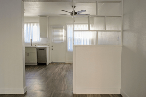 A white kitchen with a fan on the ceiling.