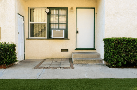 A house with a white door and window with green trim.