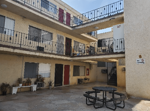 A patio with a table and chairs is surrounded by apartment buildings.
