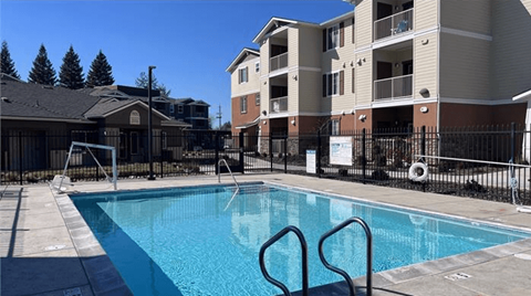 A swimming pool in front of apartment buildings.
