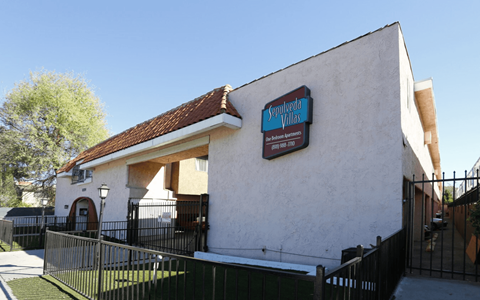 A white building with a red roof and a sign that says "Santana".