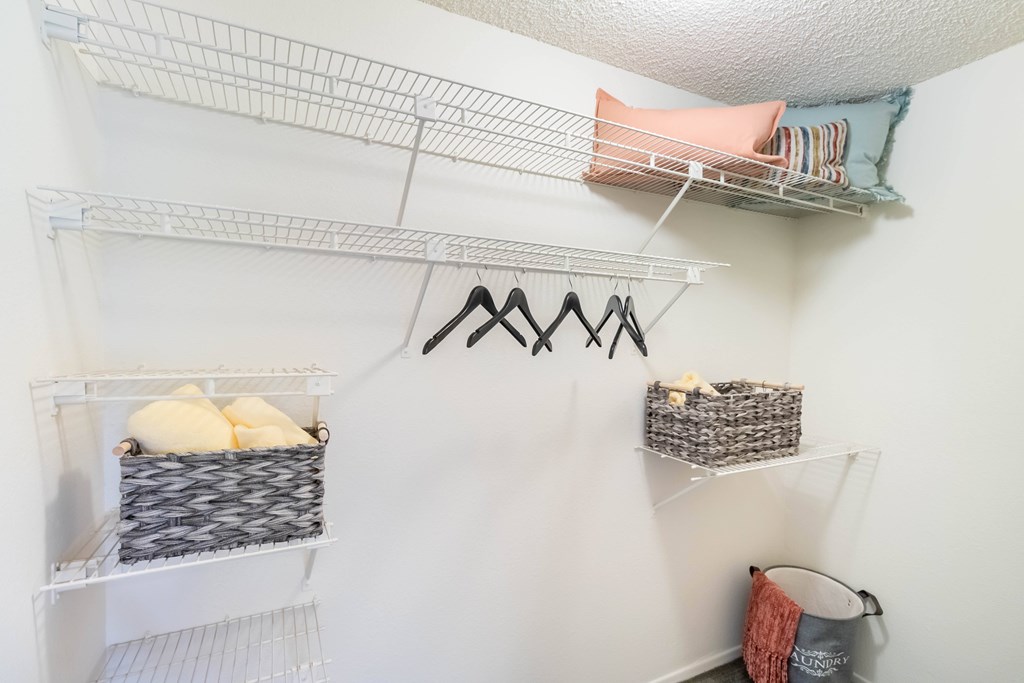 A white closet with shelves and hangers at Chaparral Apartments, Palmdale 93551