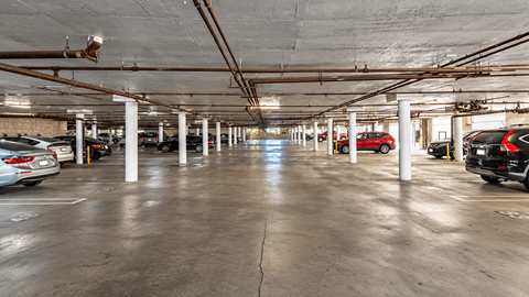 A spacious parking garage with multiple cars parked.